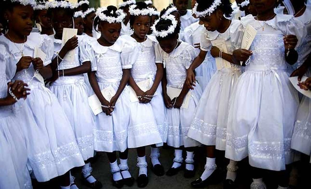 Un grup de nenes esperen que els facin una foto de grup després d’haver fet la primera comunió a l’església catòlica de St. Pierre, a Port-au-Prince (Haití).
