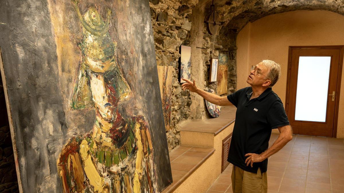 El periodista Josep Playà, davant l’oli 'El guerrer' de Patxè, que s'exhibeix a la Rectoria de Garriguella fins aquest diumenge.