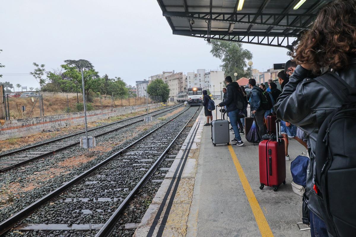 Los viajeros observando desde el único andén operativo en Alcoy cómo el tren llega a la estación.