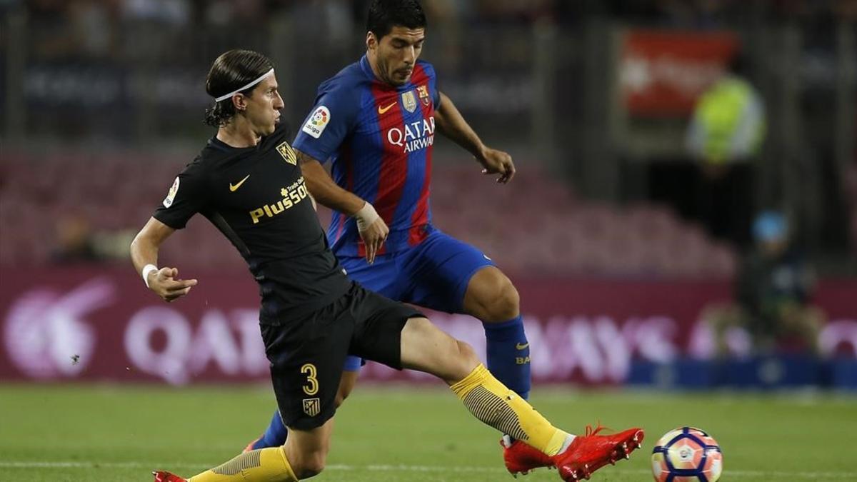 Filipe Luis intenta frenar un ataque de Luis Suárez en el Camp Nou.