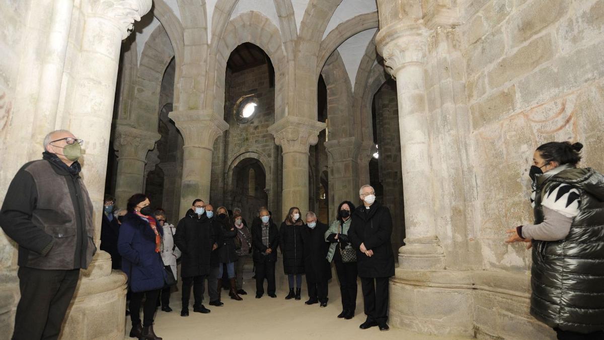 La comitiva diocesana y miembros del gobierno atienden las explicaciones de la guía en la iglesia monacal.