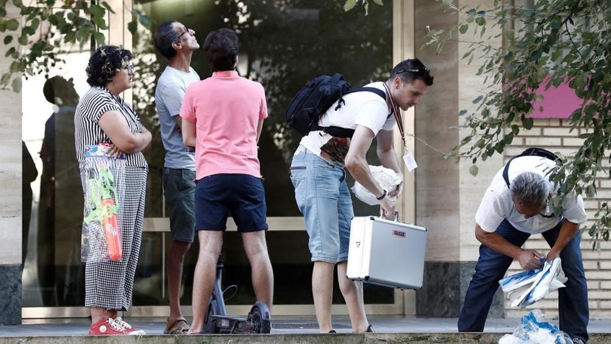 Efectivos de la policía científica trabajan en el lugar donde cayó una mujer por el balcón en Pamplona.