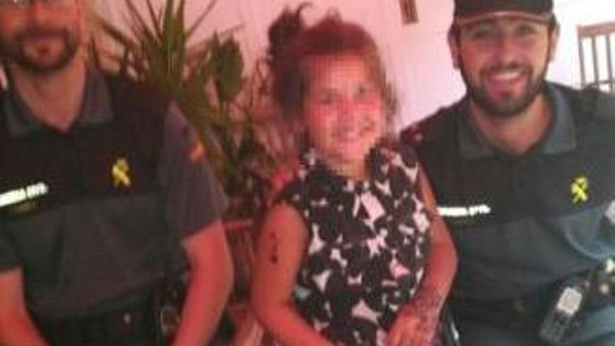 La niña, con los agentes de la Guardia Civil que la han encontrado.