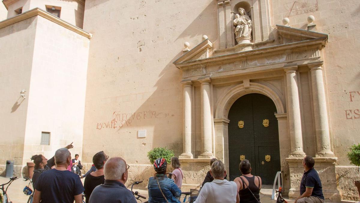 Un grupo de turistas recibe ayer las explicaciones de su guía en una excursión frente a la Concatedral de San Nicolás. | JOSE NAVARRO