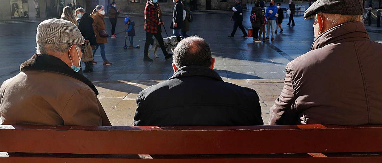 Un grupo de personas mayores en un banco de la plaza del Parche, en Avilés.