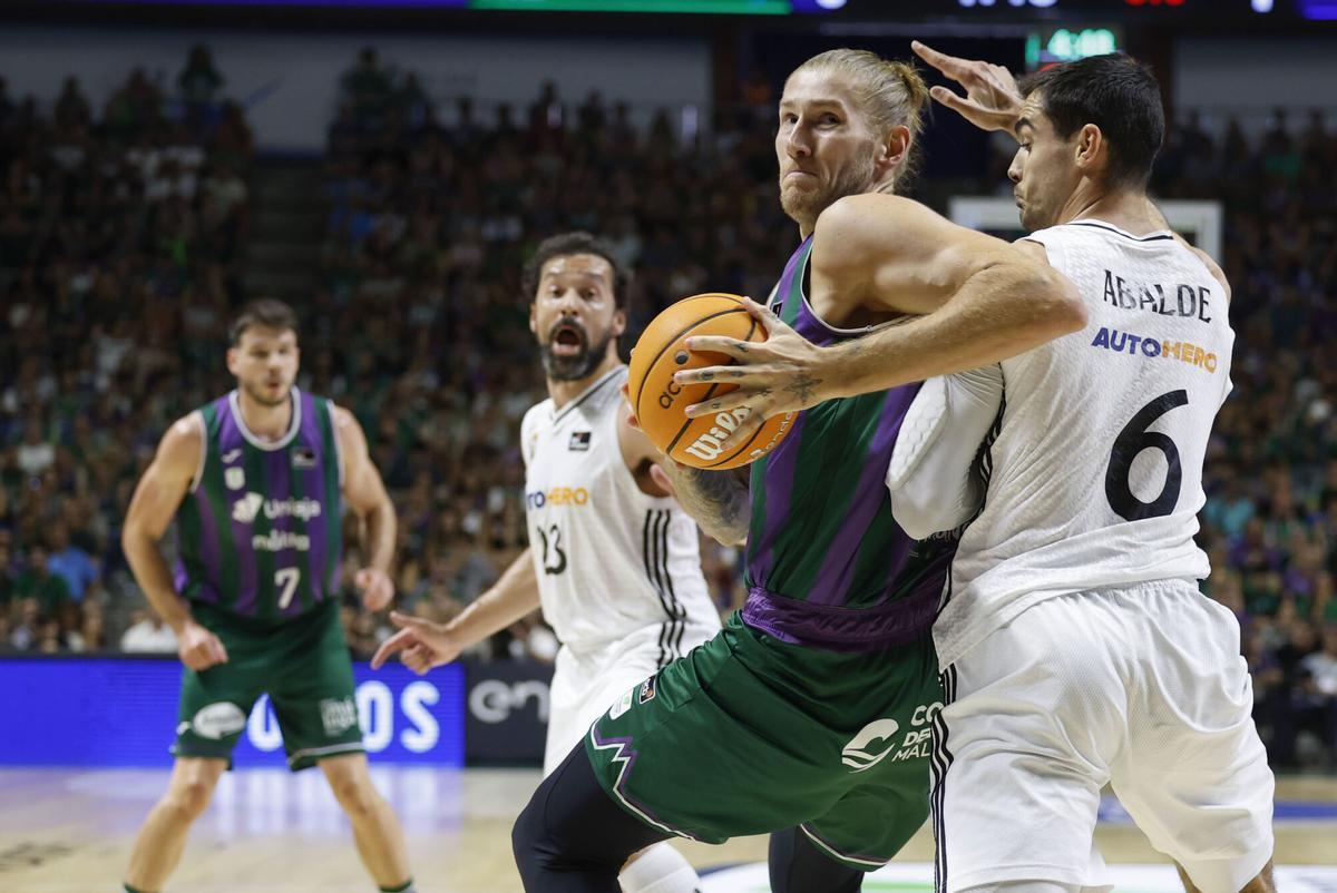 MÁLAGA, 15/06/2025.- El alero alemán del Unicaja Dylan Osetkowski (2d) en acción ante el alero del Real Madrid Alberto Abalde (d) durante el tercer partido de semifinales de la Liga Endesa de Baloncesto entreUnicaja y Real Madrid, este domingo en el Palacio de Deportes José María Martín Carpena de Málaga. EFE/ Jorge Zapata