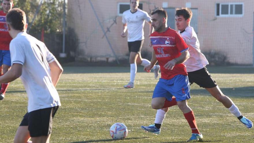 Pitu conduce el balón ante la presión de un jugador del Bueu. |  // S. ÁLVAREZ