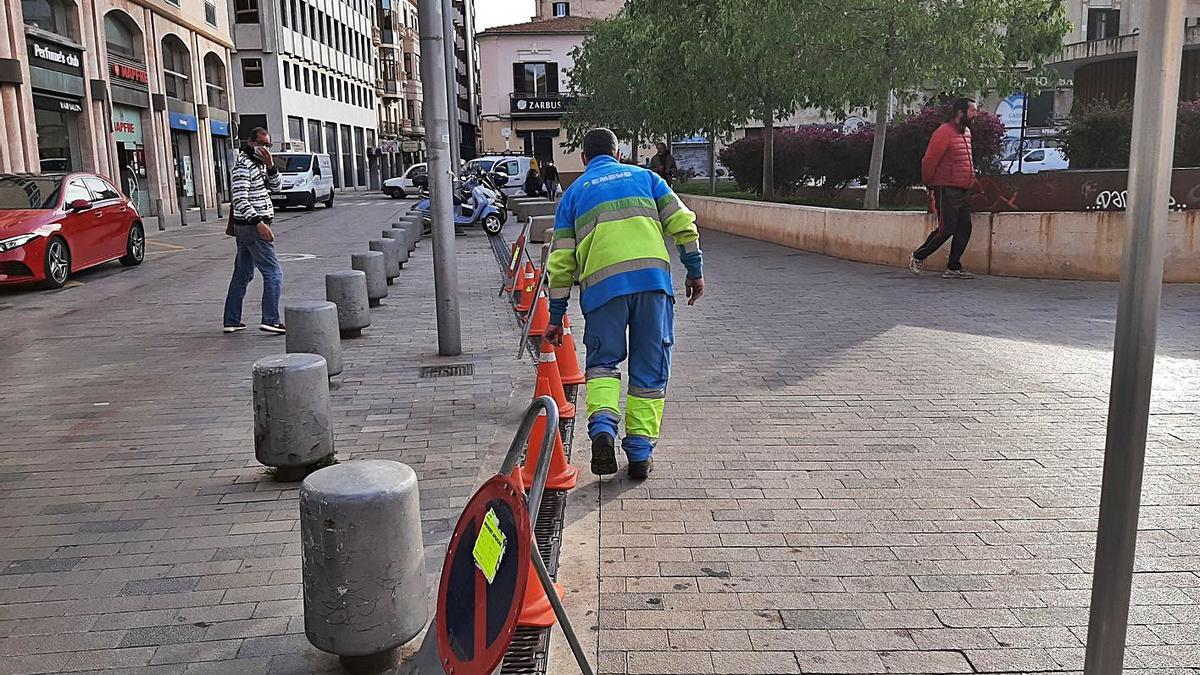 Operarios de Emaya limpiando un imbornal continuo de la plaza del Comtat del Rosselló