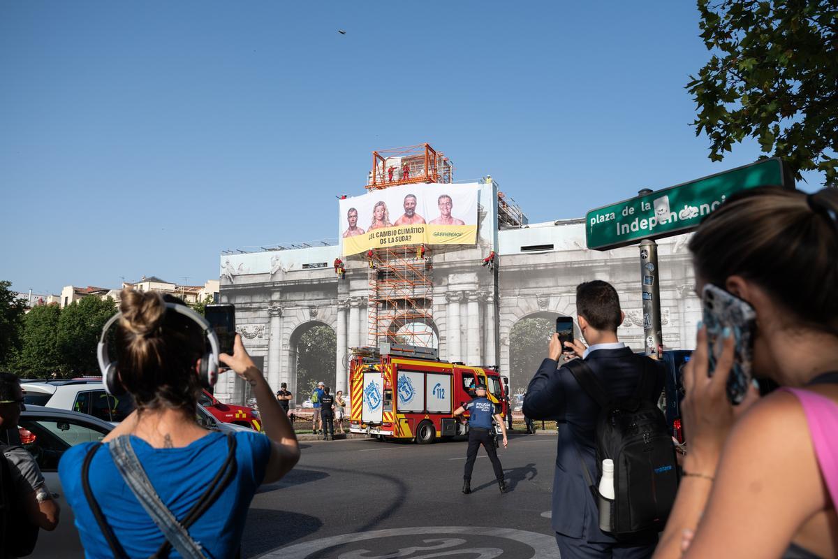 Activistas de Greenpeace han colgado hoy una pancarta en la Puerta de Alcalá