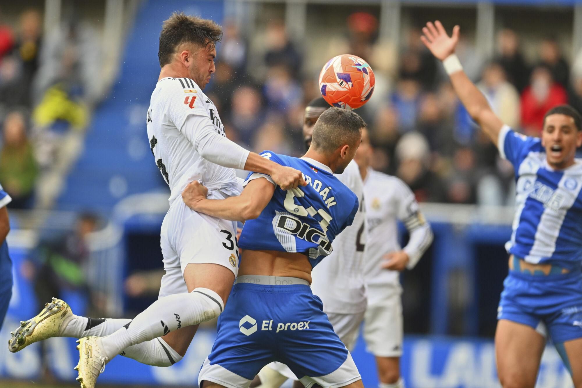 Real Madrid's Raul Asencio, left and Alaves' Joan Jordan challenge for the ball during a Spanish La Liga soccer match between Alaves and Real Madrid at the Mendizorroza stadium in Vitoria, Spain, Sunday April 13, 2025. (AP Photo/Miguel Oses) Associated Press/LaPresse. EDITORIAL USE ONLY/ONLY ITALY AND SPAIN