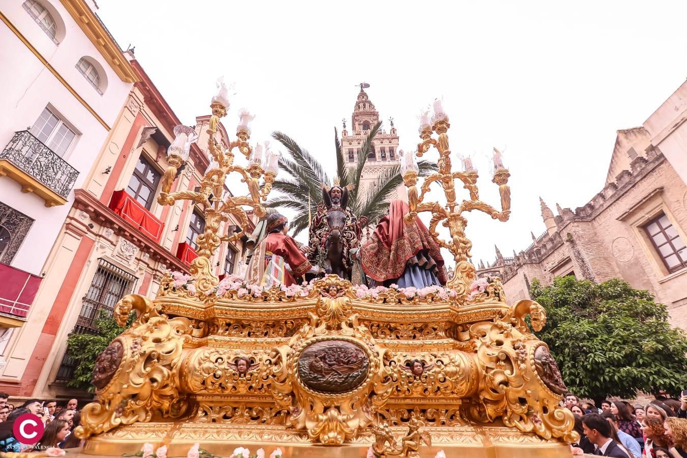 El paso de la Borriquita avanza por su recorrido con la Giralda al fondo