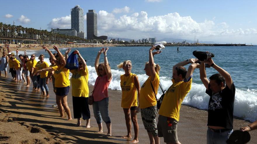 Veïns de la Barceloneta fent l&#039;onada a la platja en la concentració en defensa del barri i en contra dels efectes de la massificació del turisme