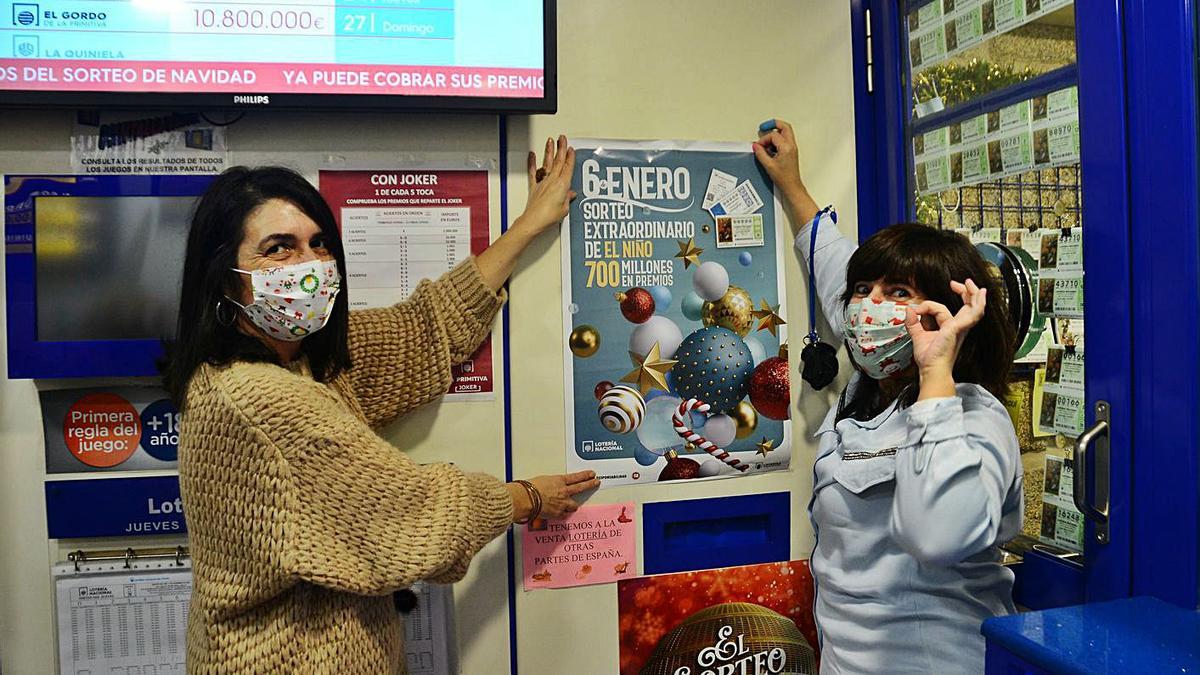 Una de las administraciones de lotería de Cangas coloca los carteles del sorteo de El Niño.   | // G.NÚÑEZ