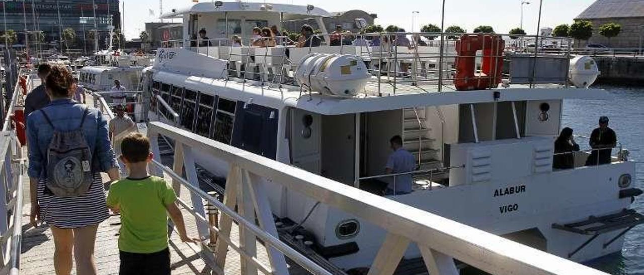 Pasajeros suben a uno de los barcos del transporte de ría. // M. Canosa