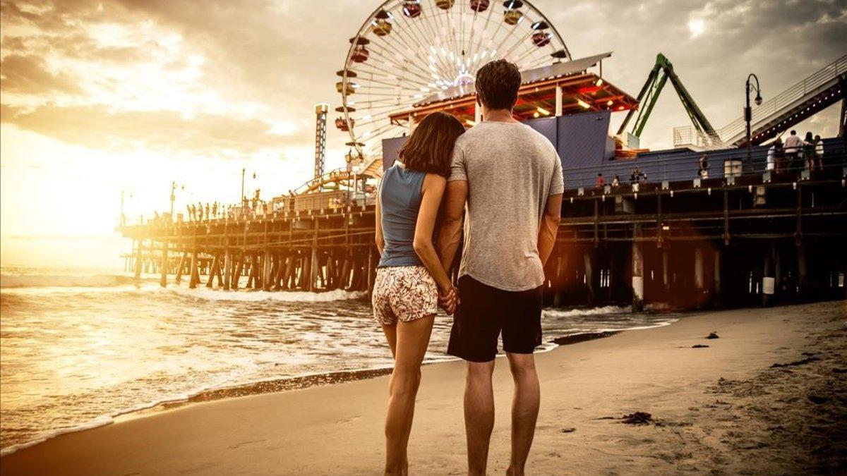 Una pareja en la playa viendo una feria