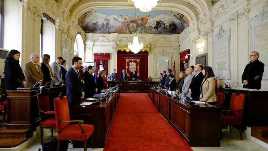 Minuto de silencio en el pleno del Ayuntamiento de Málaga, que ha puesto un crespón negro en la bandera de la fachada del edificio consistoria.