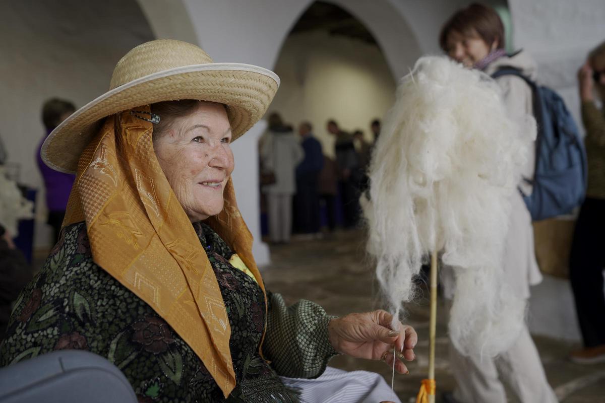 Una mujer confecciona una tela de manera artesanal