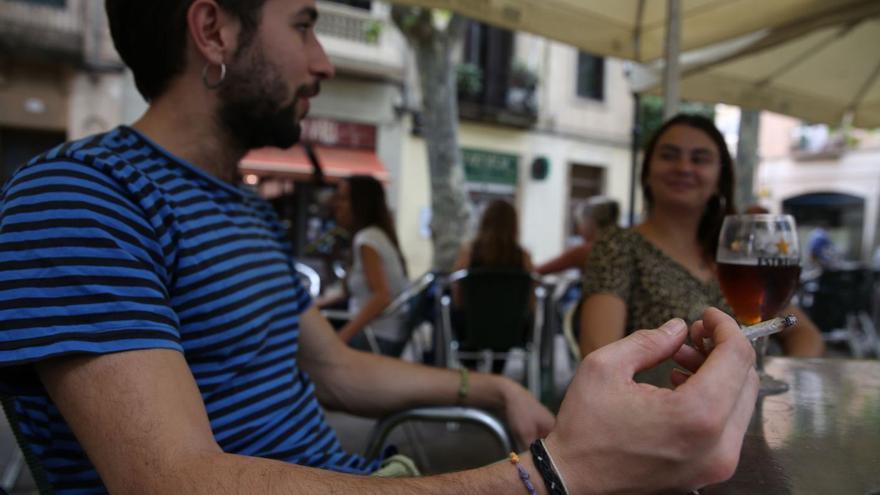 Un joven fuma en la terraza de un bar. |  // ELISENDA PONS