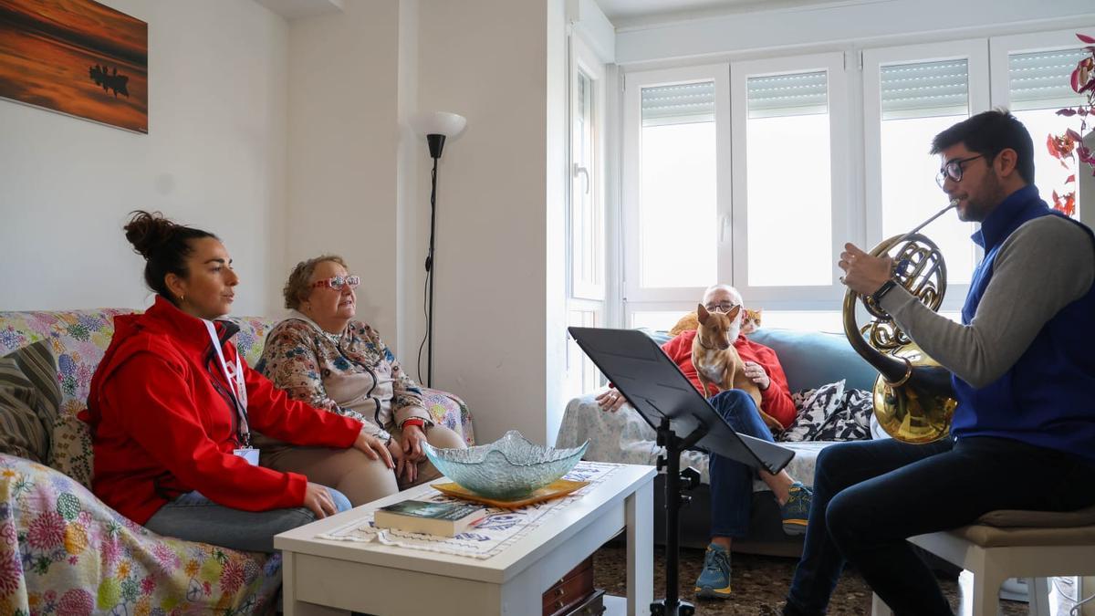 Pilar y Amadeo disfrutan del concierto ofrecido por Eliseo en el salón de su casa junto a Elisa, de Cruz Roja