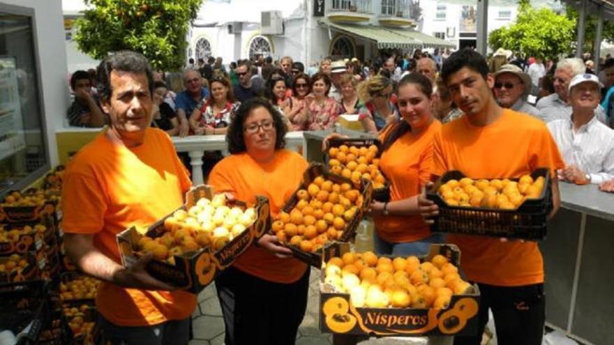 Un grupo de vecinos en uno de los expositores de nísperos.