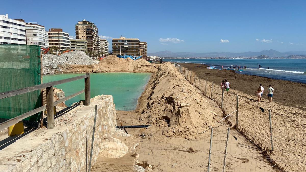 Vallas metálicas en torno al antiguo hotel, que han tenido que colocarse en la arena