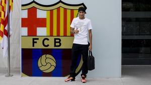 Neymar posa junto al escudo blaugrana de las oficinas del club en su primera aparición en Barcelona.