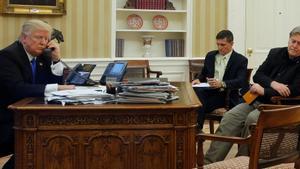 U.S. President Donald Trump (L), seated at his desk with National Security Advisor Michael Flynn (2nd R) and senior advisor Steve Bannon (R), speaks by phone with Australia’s Prime Minister Malcolm Turnbull in the Oval Office at the White House in Washington, U.S. January 28, 2017. REUTERS/Jonathan Ernst