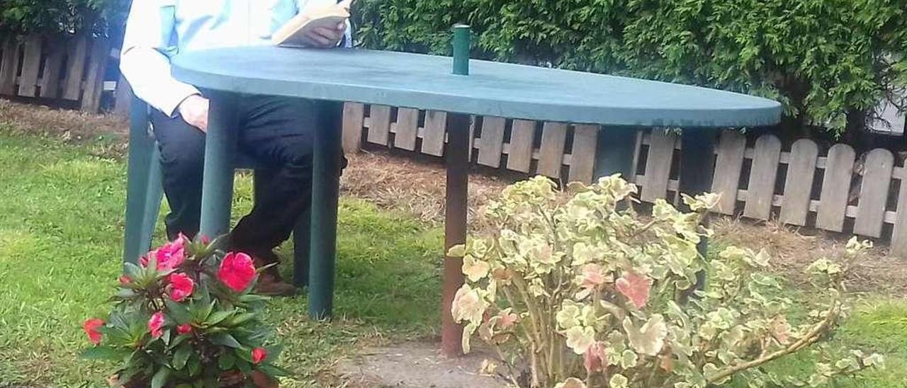 Eduardo Román, leyendo, en el jardín de su casa carreñense.