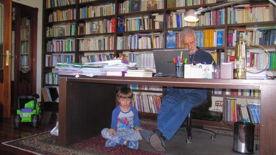 El académico, trabajando con su nieto Adrián bajo la mesa.