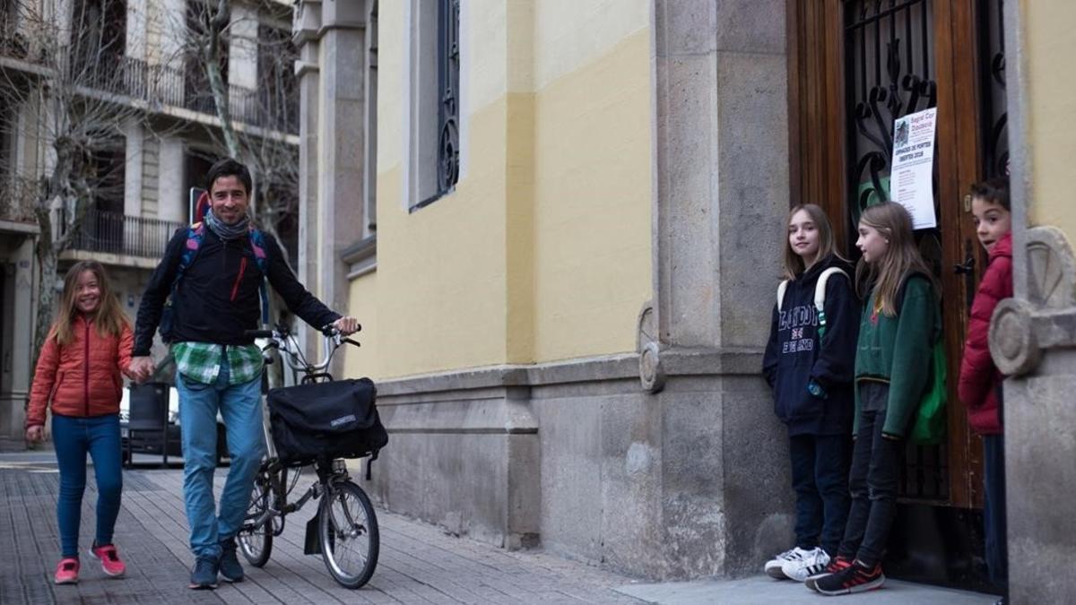 Un padre lleva a su hija al colegio antes de ir al trabajo