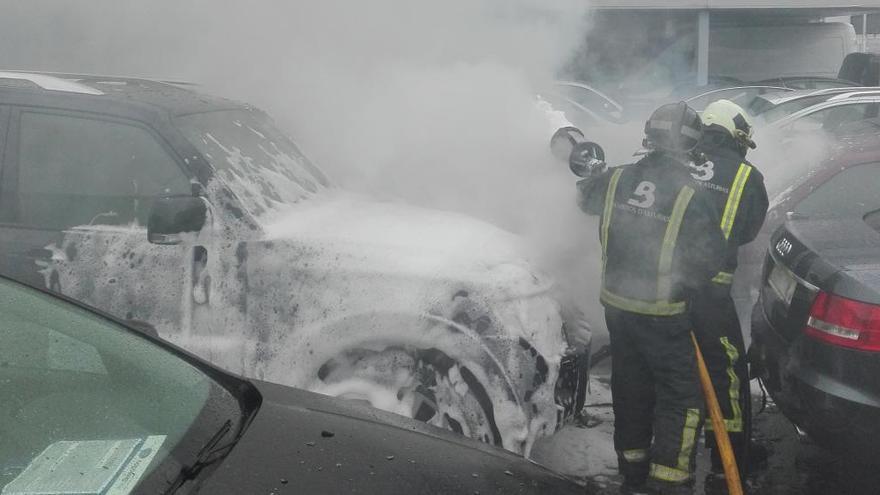 Bomberos apagando las llamas de los vehículos.