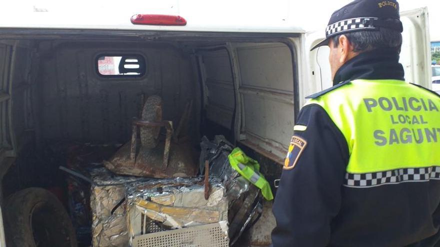 Un agente de la Policía Local de Sagunt inspecciona la furgoneta con la chatarra robada.