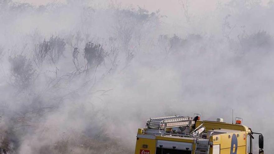 Un bombero prepara la manguera para sofocar las llamas.