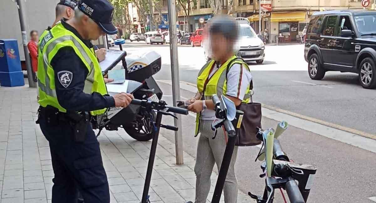 Un agente de la Policía Local comprueba la documentación de un patinete eléctrico.