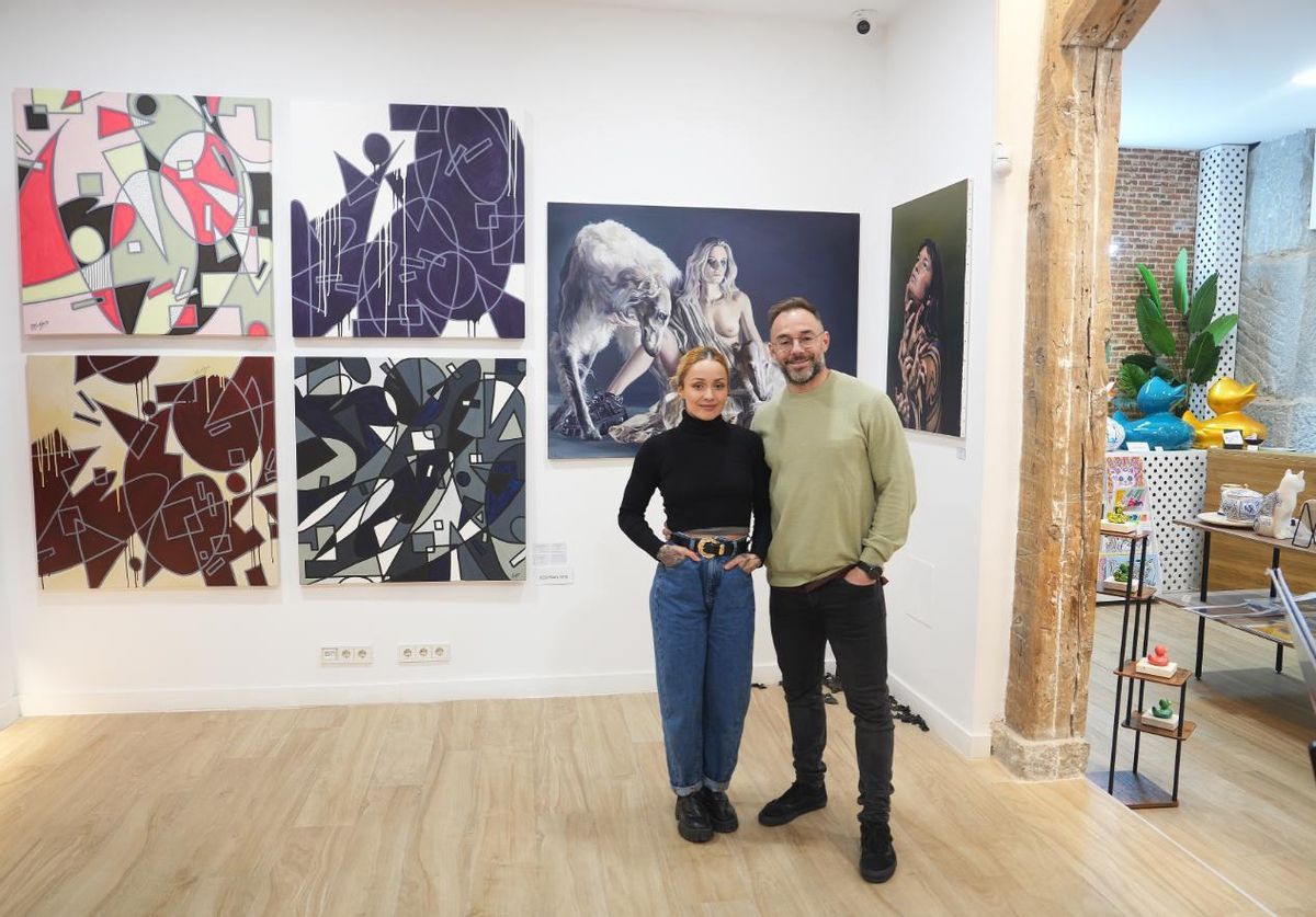 Tamara López y Roberto Blanco, en su galería delante de pinturas de Nora Beltrán y, a la izda, Desorden Arts.