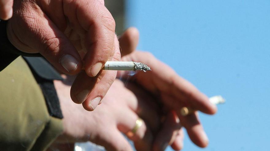 Una persona consumiendo un cigarrillo, en un partido de fútbol en Ourense. |   // I. OSORIO