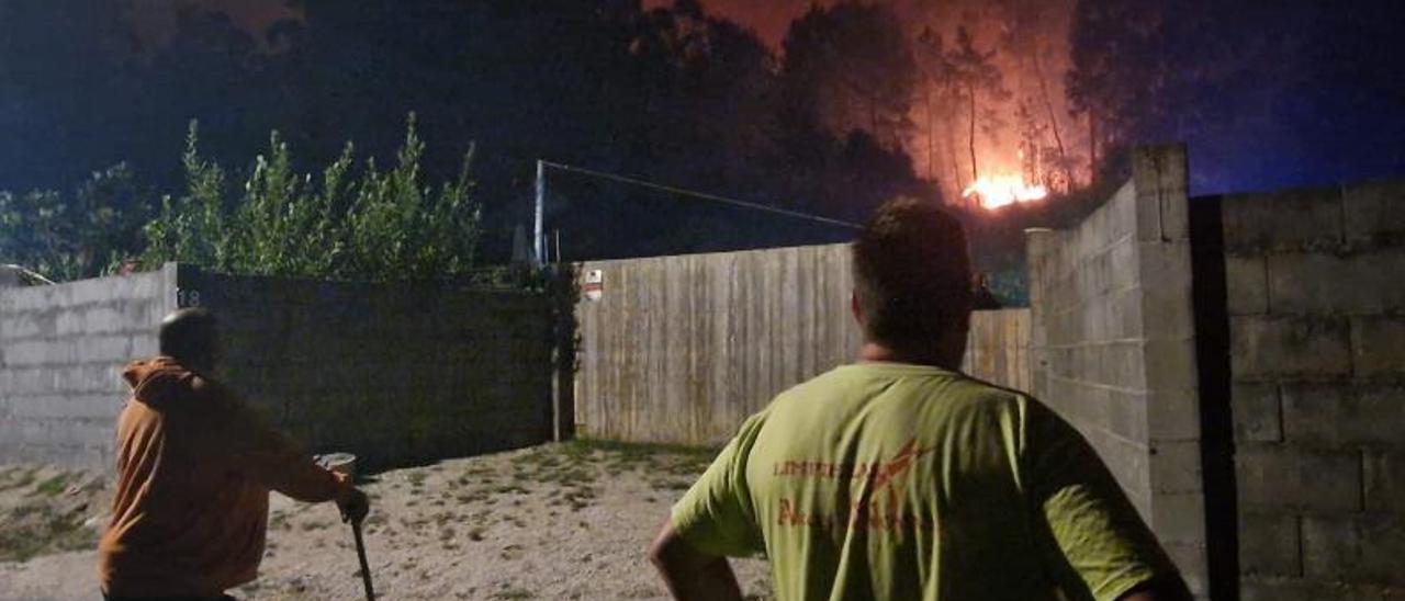 Dos vecinos observan el avance de las llamas, en la madrugada del 5 de agosto. |   // M.MÉNDEZ