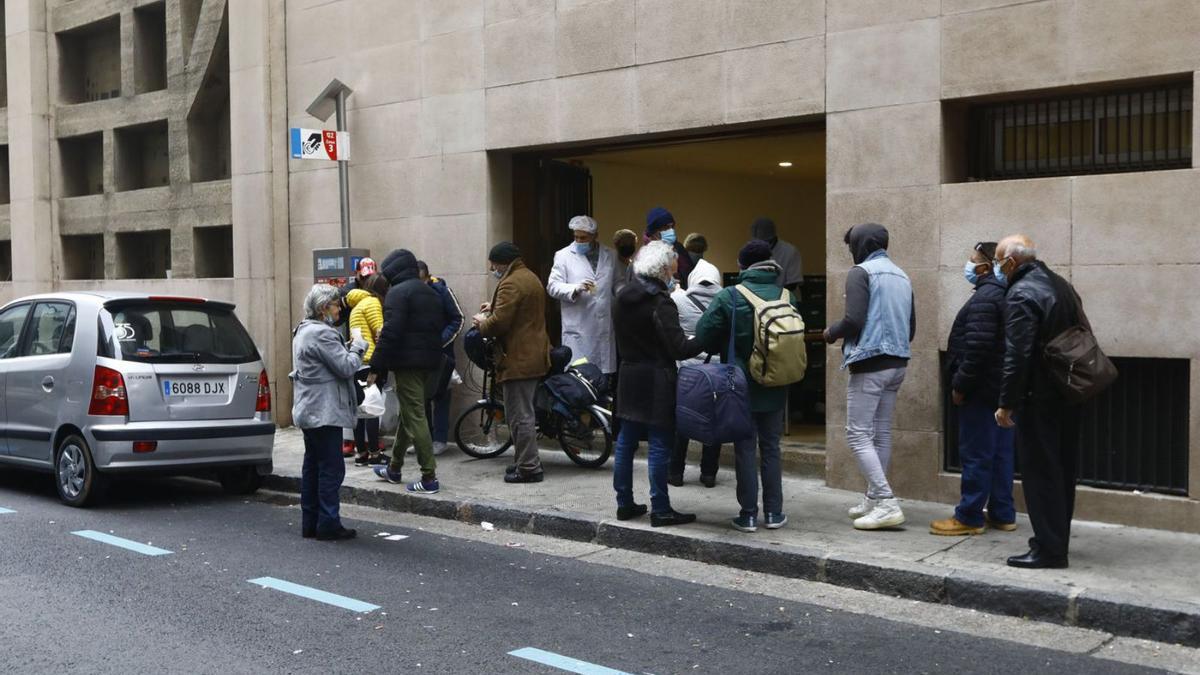 Varias personas esperan en la parroquia de El Carmen para recibir comida calienta.  | ANDREEA VORNICU