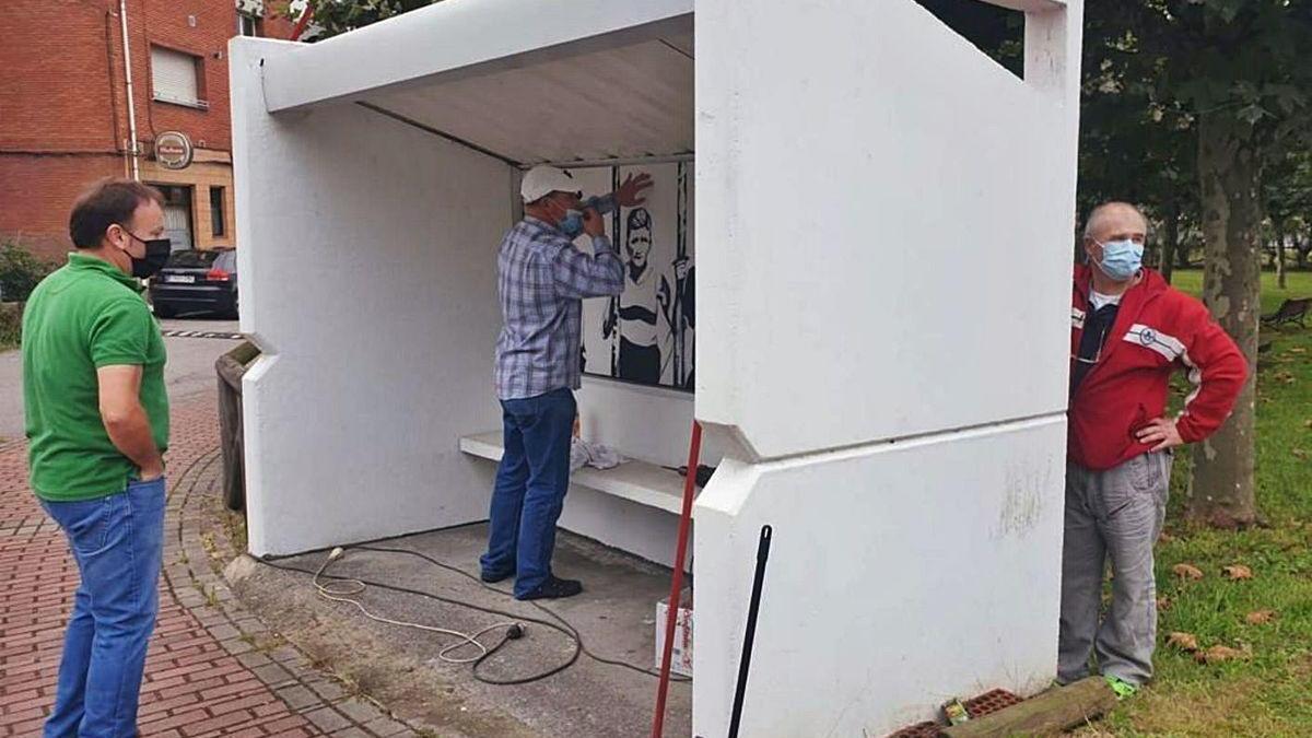 Vecinos de Laviana realizando labores de mantenimiento de una de las marquesinas de la &quot;Ruta Parades&quot;.