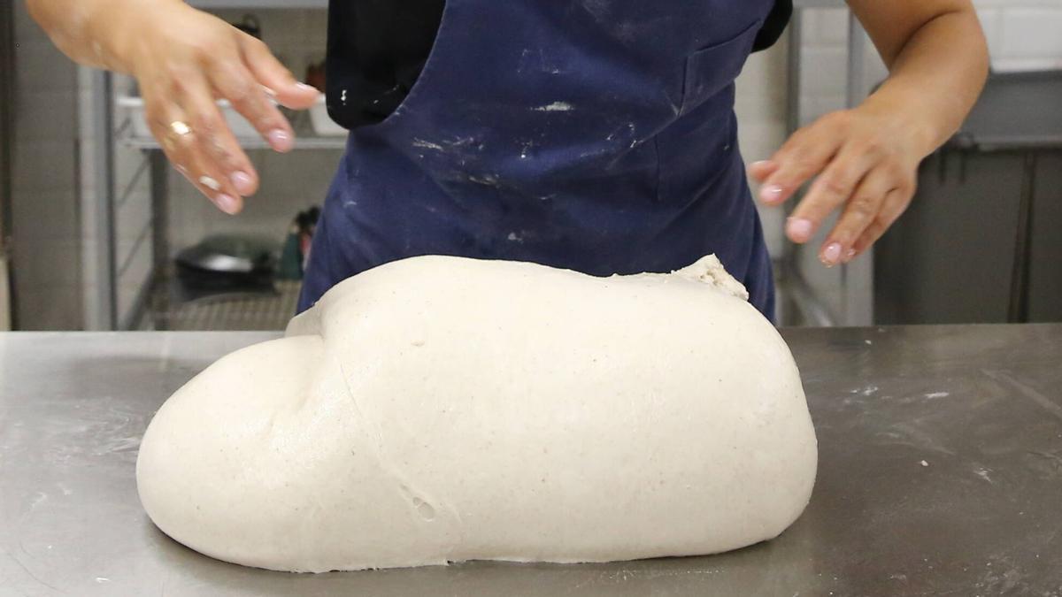 Una joven trabaja la masa en una pastelería de Barcelona.