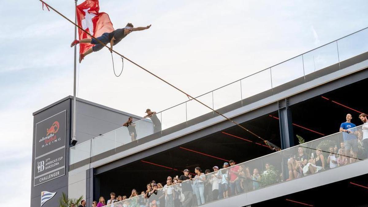 Un atleta de Red Bull en una demostración de 'slackline' en el estreno de la base del equipo suizo de la Copa América de vela, en Barcelona.