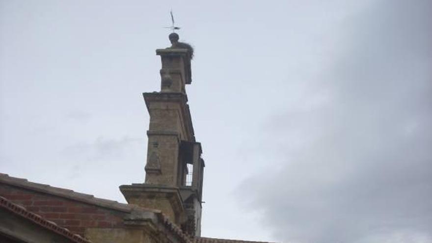 El concejal Carlos Torrijos apunta hacia la espadaña de la iglesia.