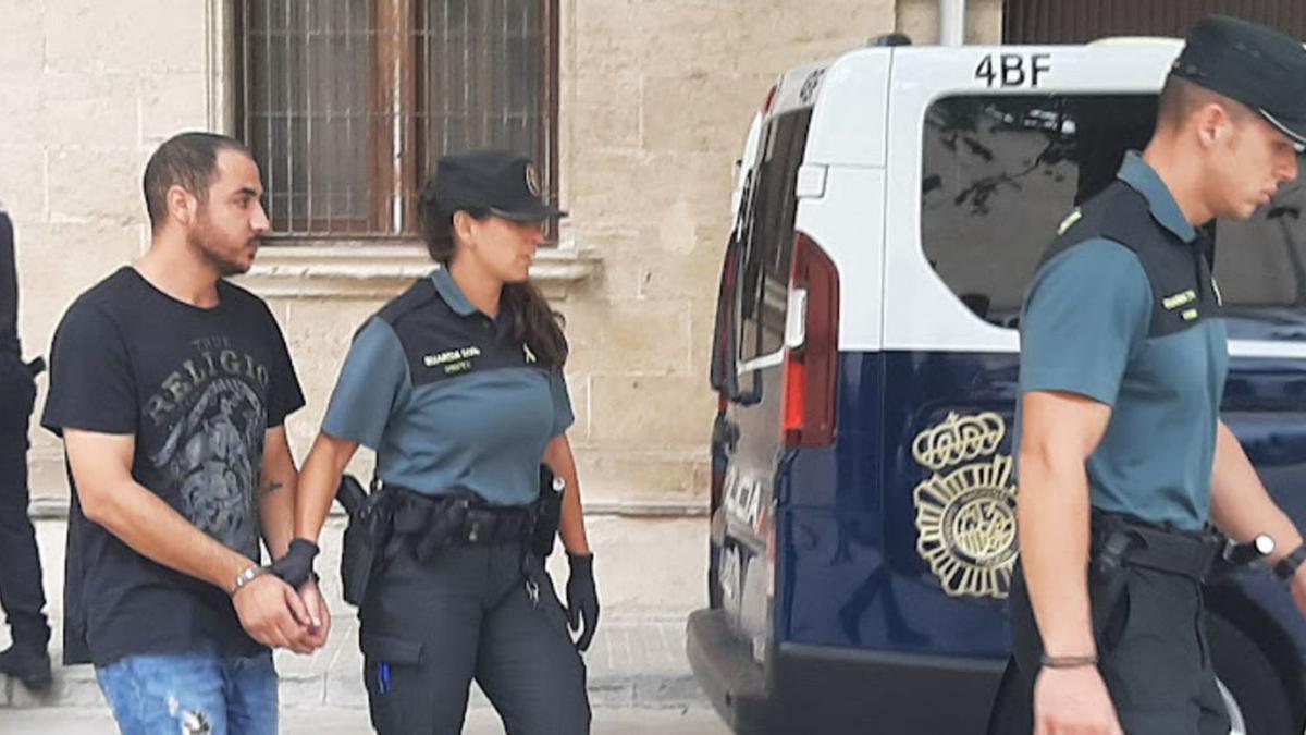 Agentes de la Guardia Civil conducen, ayer, a prisión al presunto incendiario.