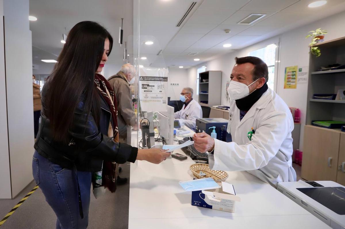 Un profesional entrega una mascarilla a una usuaria en el centro de salud de avenida de América.