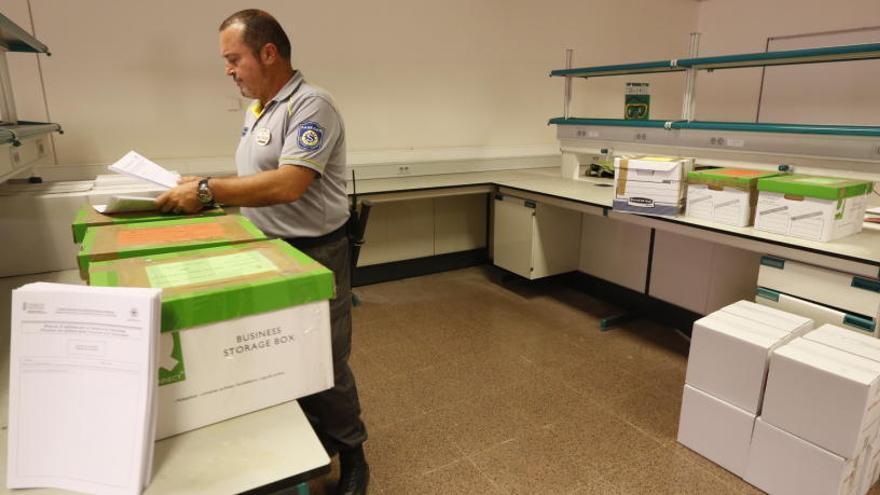 Un vigilante de seguridad con las cajas que contienen los exámenes de Selectividad en la UMH.
