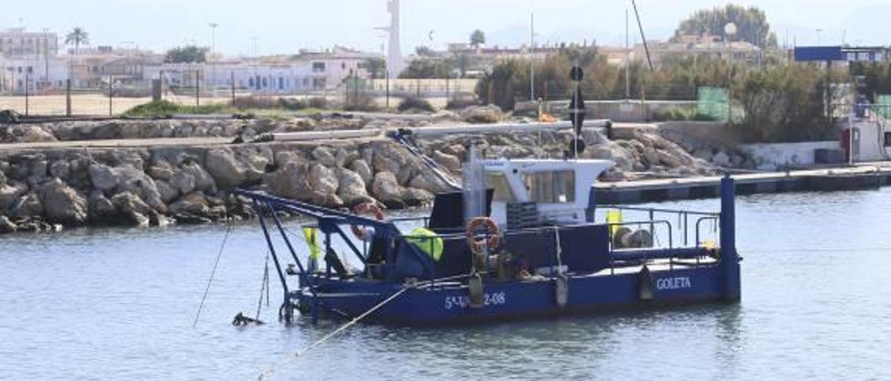 El agua negra del dragado del puerto de Oliva sorprende  a los visitantes de la playa