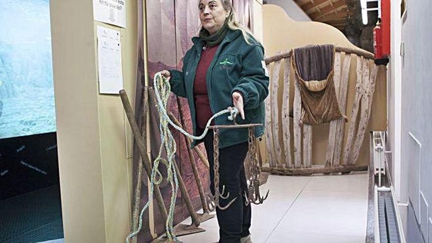 Julia Sendín muestra el utensilio utilizado para extraer calderos de los pozos artesanos.