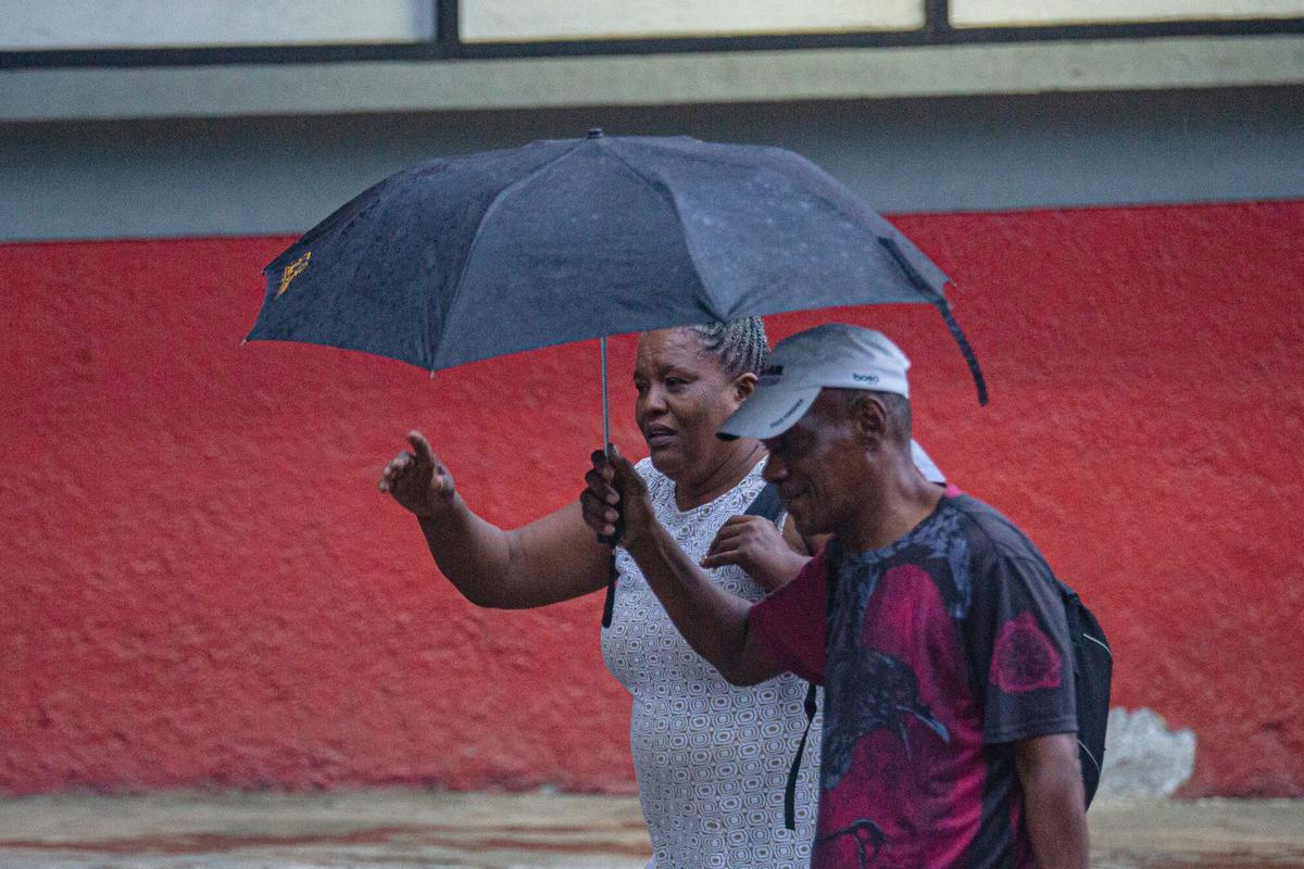 Una pareja camina bajo la lluvia este viernes, en Puerto Príncipe (Haití). EFE/ Mentor David Lorens