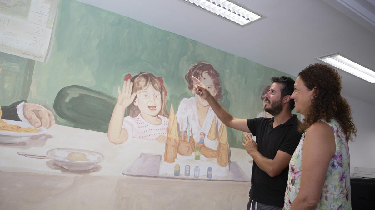 Catalina Cladera y el artista Joan Aguiló junto al mural de la nueva Oficina de Atención Ciudadana del IMAS en Palma