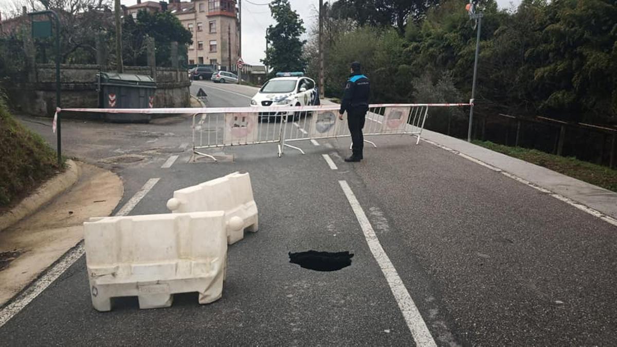 Un agente de la Policía Local, junto al socavón y el tramo cerrado